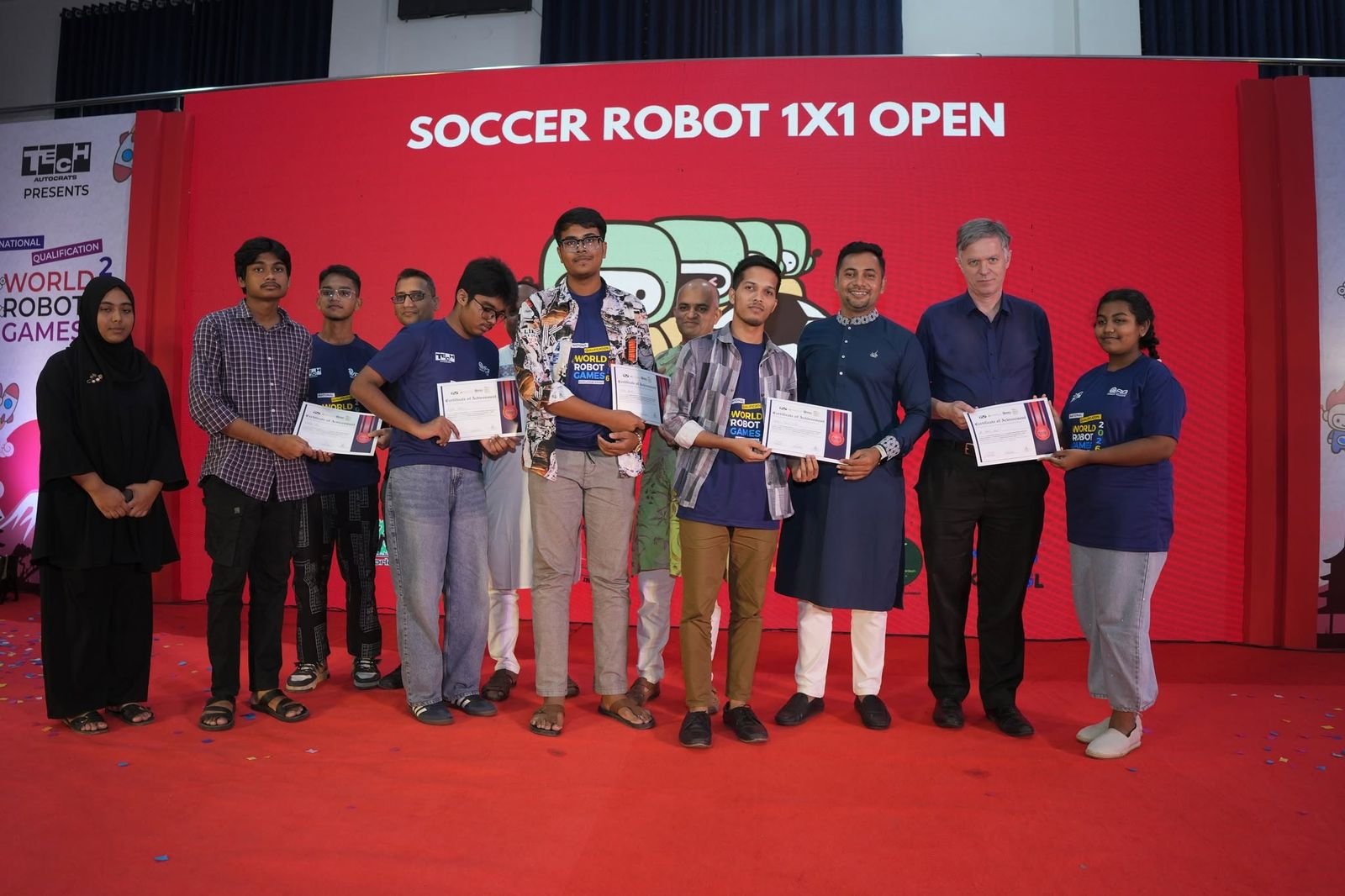 Soccer Robot 1×1 Open finishers hold their certificates on stage alongside guests