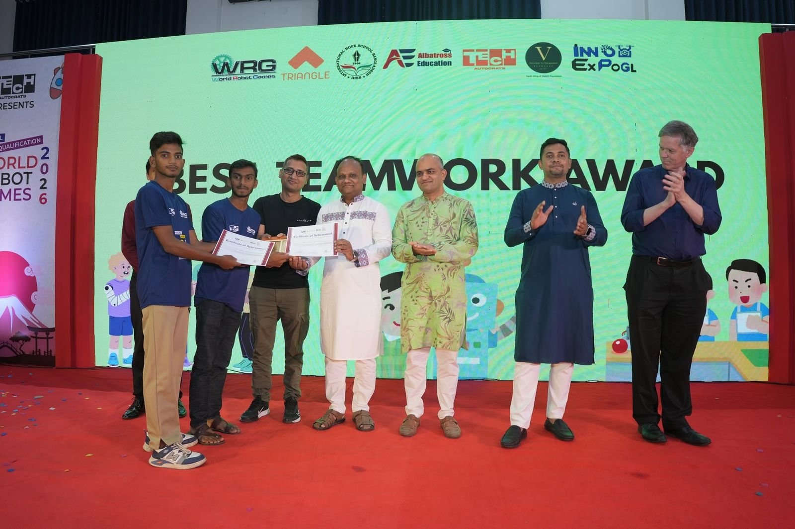 A team accepts the Best Teamwork Award on stage from guests