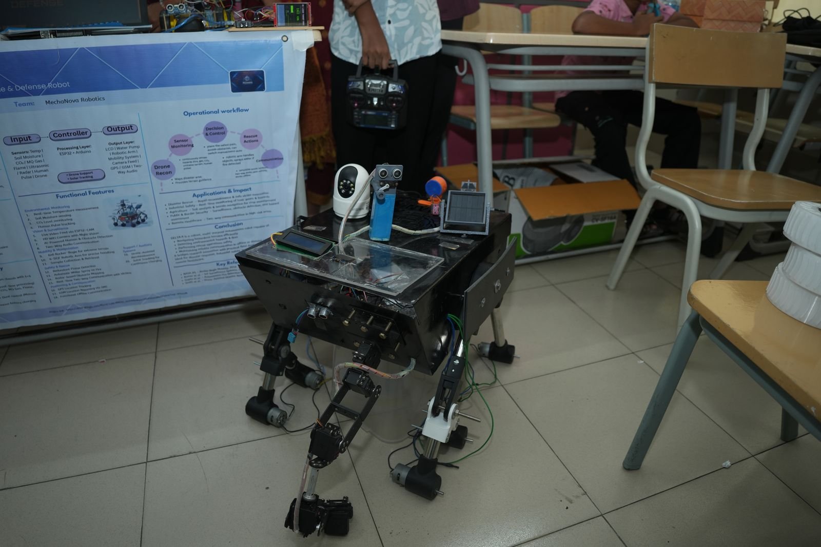 A four-legged robot standing in front of its project poster